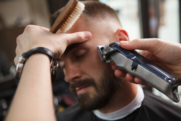 Cropped close up of a man having his beard shaved by professional barber