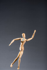 wooden marionette in tie on black background