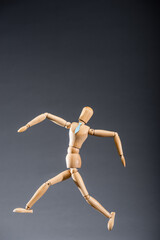 wooden marionette in tie on black background