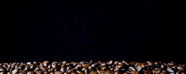 Сoffee beans  on a bright dark background. Copy space for text and panoramic frame