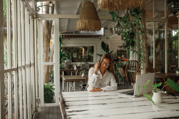 Creative businesswoman using laptop in office, talking the phone