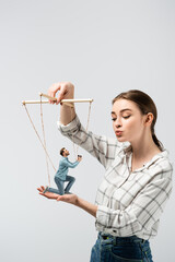 female puppeteer kissing male marionette with ring box isolated on grey
