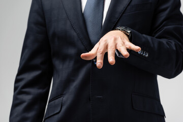 cropped view of businessman in suit manipulating with hand isolated on grey