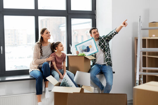 mortgage, family and real estate concept - happy mother, father and little daughter with stuff in boxes moving to new home