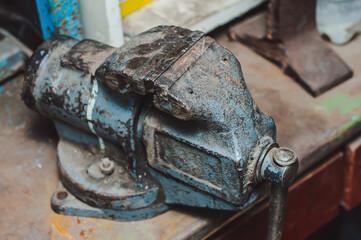 Old vintage steel vise on a garage shelf, an indispensable tool