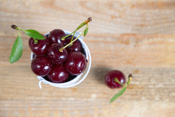 Cherry with leaves on a wooden table. View from above.