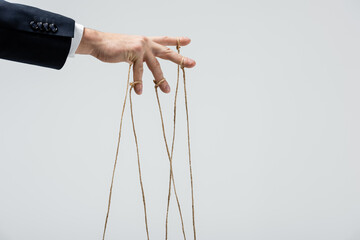 Fototapeta na wymiar partial view of puppeteer with strings on fingers isolated on grey