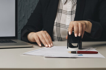 Close up on woman's notary public hand stamping the document. Notary public concept.