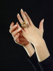 ....Beautiful female hands put on a ring with a large crystal...