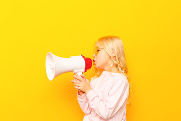 Kid shouting through vintage megaphone. Communication concept. Blue sky background as copy space for your text.