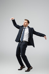 businessman marionette in suit posing with raised hands isolated on grey