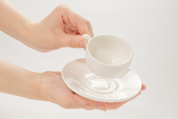 Empty coffee cup in woman hand isolated on white.