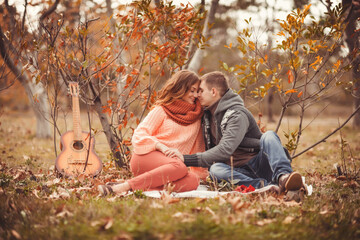 Young couple in love outdoor.Stunning sensual outdoor portrait of young stylish fashion couple posing in park in autumn
