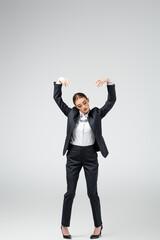 businesswoman marionette in suit posing isolated on grey