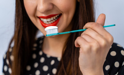 Portrait of beautiful young woman with toothbrush in hands. Healthy white teeth. Dental concept.