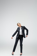 businesswoman marionette in suit posing isolated on grey