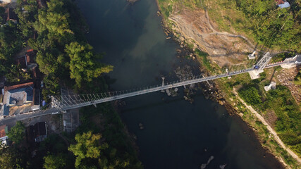 Fototapeta premium aerial view of a suspension bridge that crosses the Opak river in Bantul. Yogyakarta Indonesia