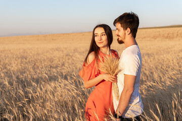 Beautiful couple of man women wheat field. Girl keep bouquet of dried wheat .