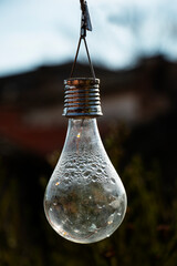 close-up of hanging light bulb with drops of condensation