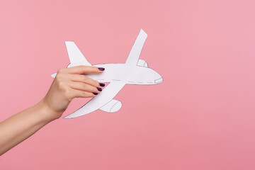 Closeup hand holding paper plane, advertise of airline service, plane landing or departure, concept...