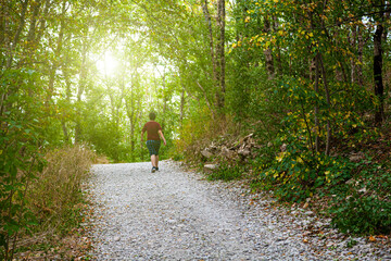 Young man walks along a path in a mountain forest.