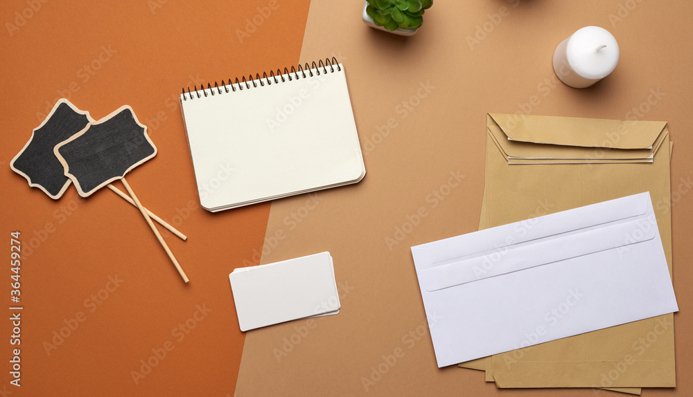 Poster brown paper envelope and empty notebook on a brown background