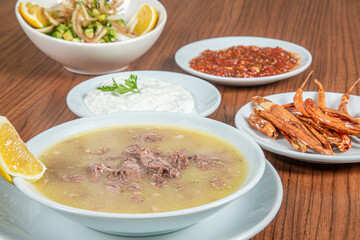 Turkish Traditional Soup with bread on white rustic wooden background, kelle, paca corbasi.