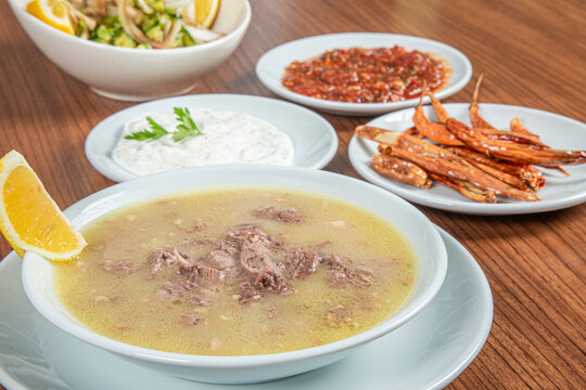 Turkish Traditional Soup with bread on white rustic wooden background, kelle, paca corbasi.