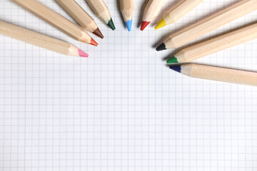 Obraz premium Flat lay view of white notebook , color pencils on a table. Preparing for a school. Back to school.