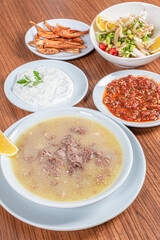 Turkish Traditional Soup with bread on white rustic wooden background, kelle, paca corbasi.