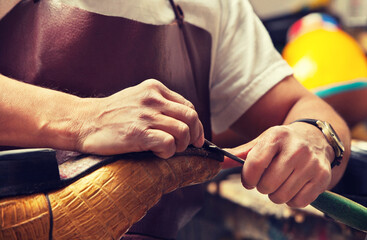 Cobbler craftsman fixing leather boot using tools