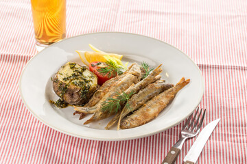 Seafood deep fried fish served with baked potato and beer on fabric napkin