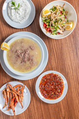 Turkish Traditional Soup with bread on white rustic wooden background, kelle, paca corbasi.