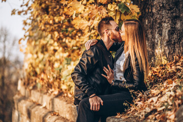 Fototapeta premium Sunny portrait of a young loving couple walking in the autumn park.