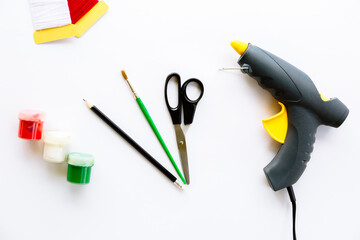 Scissors, pencil, brush, paints, gouache, acrylic, thread and glue gun isolated on a white...