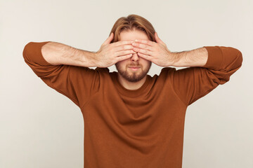 Don't want to look at this! Portrait of confused bearded man covering eyes, feeling stressed...