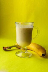 banana smoothie in a glass. 
banana cocktail, banana on a yellow background. The concept of proper nutrition