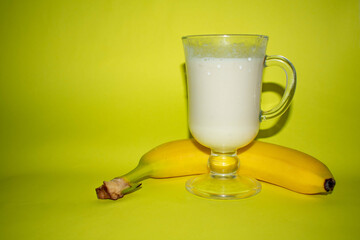 banana smoothie in a glass. 
banana cocktail, banana on a yellow background. The concept of proper nutrition