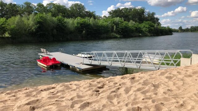 Ein Tretboot und Ruderboot liegen vertaut an einem Bootssteg