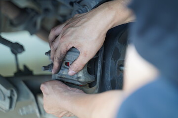 Hand working on car's disc brake
