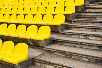 empty plastic yellow stands in a sports stadium.