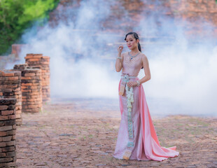 Woman wearing typical thai dress with thai style, Beauty fantasy Thai dress traditional costume on brick in old temple