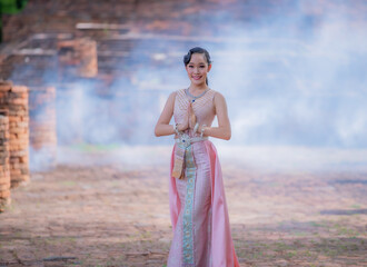 Woman wearing typical thai dress with thai style, Beauty fantasy Thai dress traditional costume on brick in old temple
