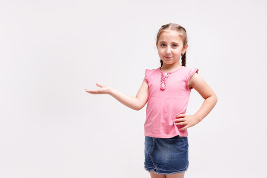 Little girl showing something over her hand on white background