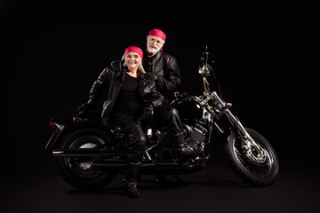 Fototapeta na wymiar Photo of aged bikers grey haired man lady soulmates couple drive vintage chopper feel young metal music festival wear rocker leather jacket pants bandana isolated black color background