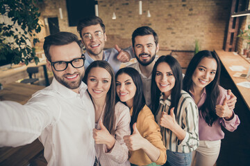 Close up photo of positive freelancers man woman students have experience anti crisis company plan development make selfie guy coach show thumb up sign in workplace workstation