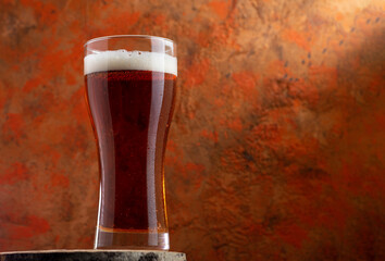 A glass of beer red ale on a concrete background