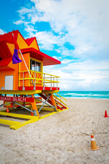 Clouds over an orange, red and yellow lifeguard tower in South Beach