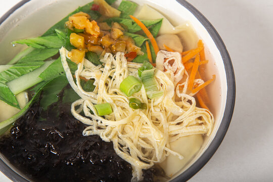 Traditional Chinese wantun soup, mushrooms and vegetables. Closed image.
