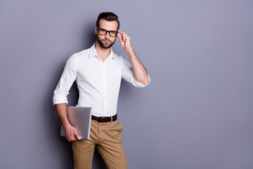 Portrait of successful reliable man marketer real estate agent hold laptop touch spectacles ready work distance wear good look outfit isolated over gray color background